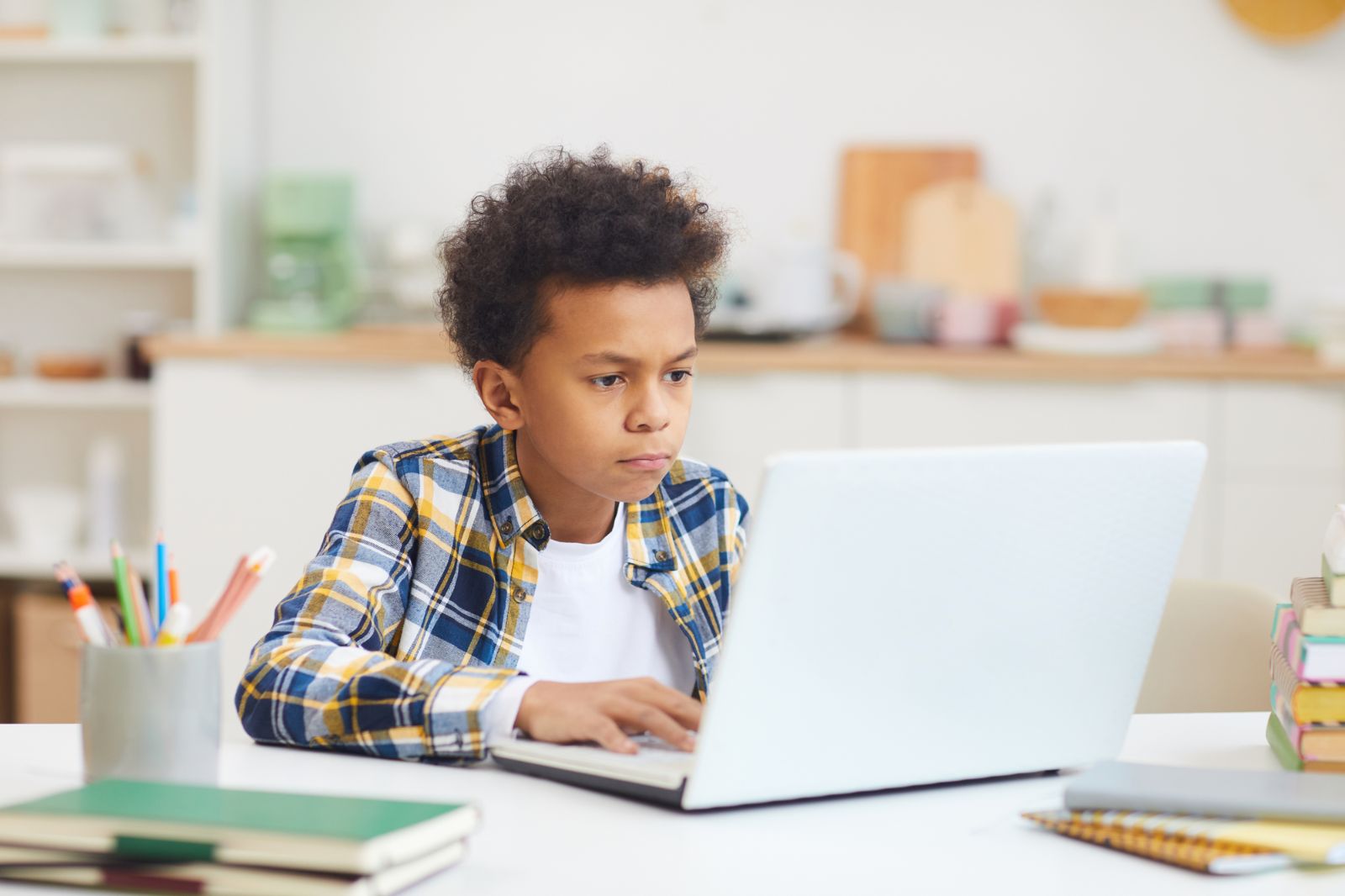 young middle school boy studying on laptop